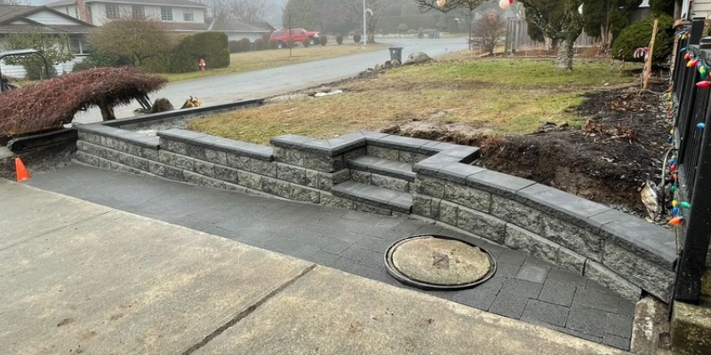 the norht side allan block wall and drive way extension completed. charcoal color pavers and silverado allan block wall with charcoal caps